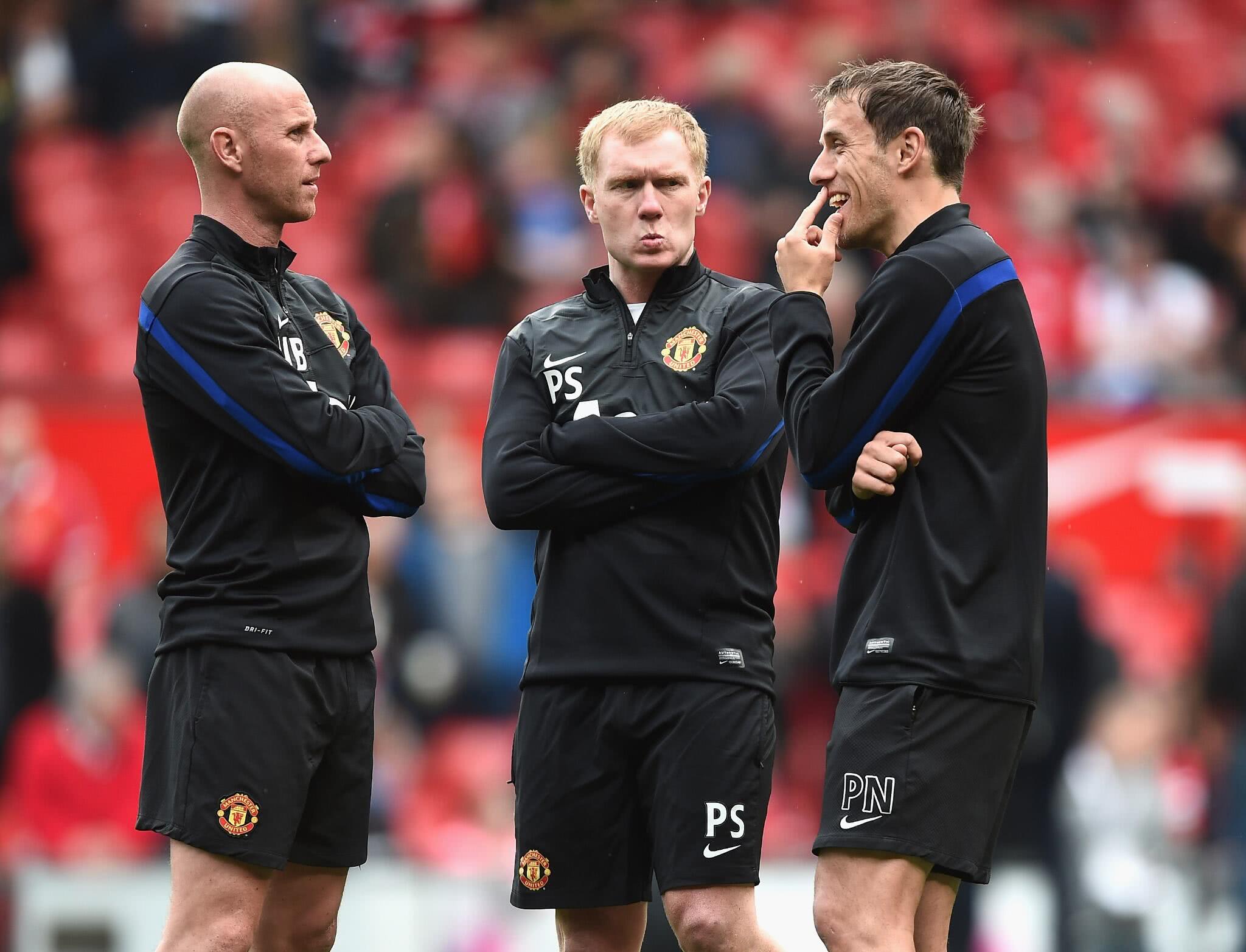 Scholes em campo com braços cruzados em seu antigo cargo como assistente técnico do Manchester United