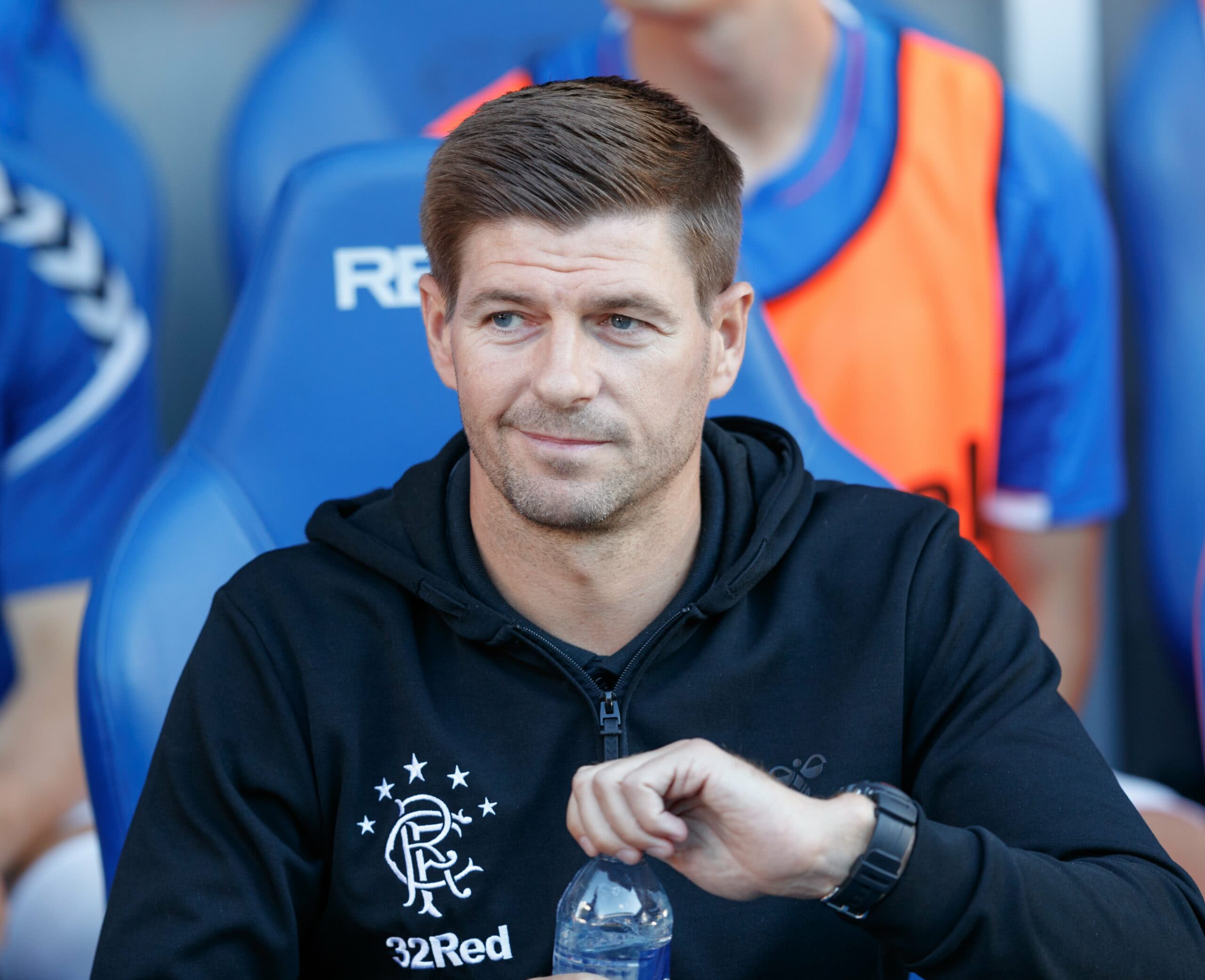 Steven Gerrard abre garrafa de água enquanto senta no banco do Rangers